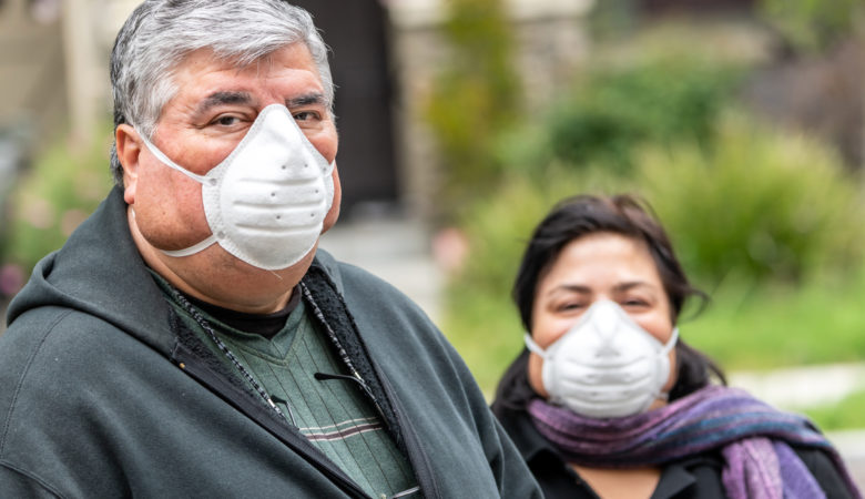 Overweight hispanic or middle eastern senior couple wearing a N95 protective mask due Covid-19 pandemic